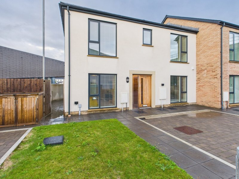 Modern two-story house with cream and brick exterior, garden, driveway and patio area