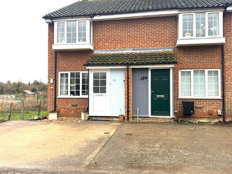 Red brick semi-detached mid terraced house with green door and driveway with free off street parking