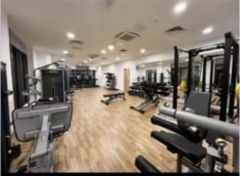 Modern gym interior with cardio equipment, free weights, and mirrored walls