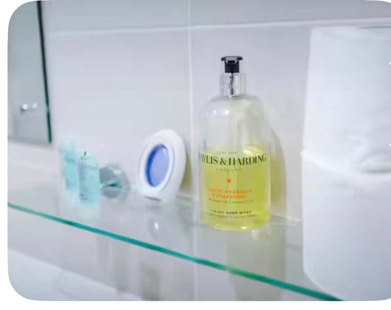 Bathroom shelf with soap dispenser, small decorative items and toiletries