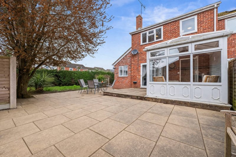 Brick house exterior with patio area, garden furniture, and countryside views