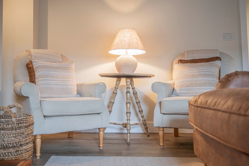 Cozy seating area with two armchairs, tripod lamp, and woven basket accents