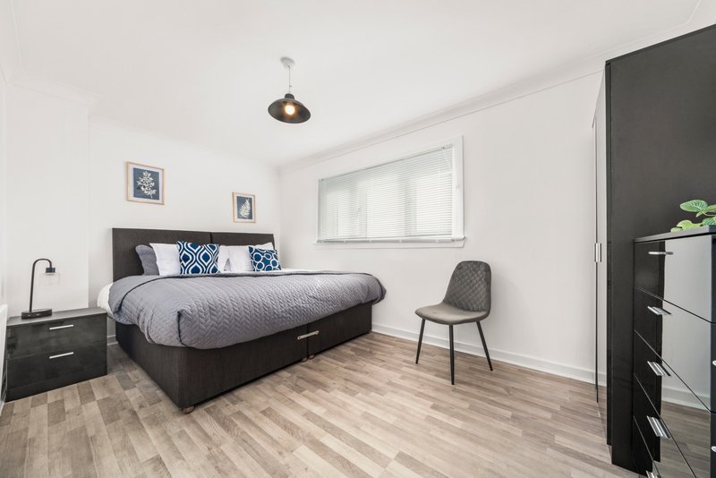 Modern bedroom with double bed, wooden flooring, pendant light and contemporary furnishings