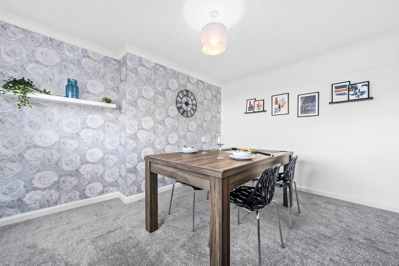 Games room with wooden pool table, modern chairs, patterned wallpaper and framed wall art