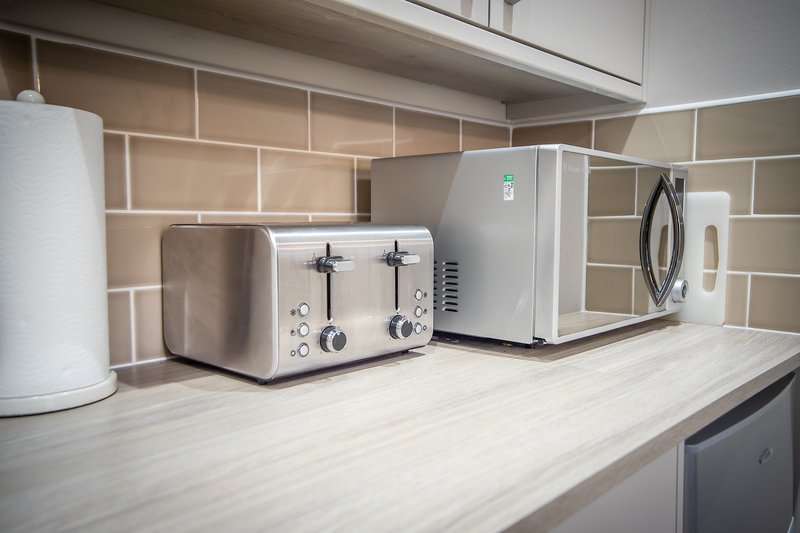 Kitchen countertop with toaster, microwave, kettle and paper towel holder