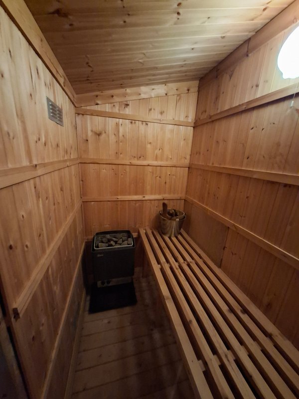 Interior of wooden sauna with bench seating and heating stove