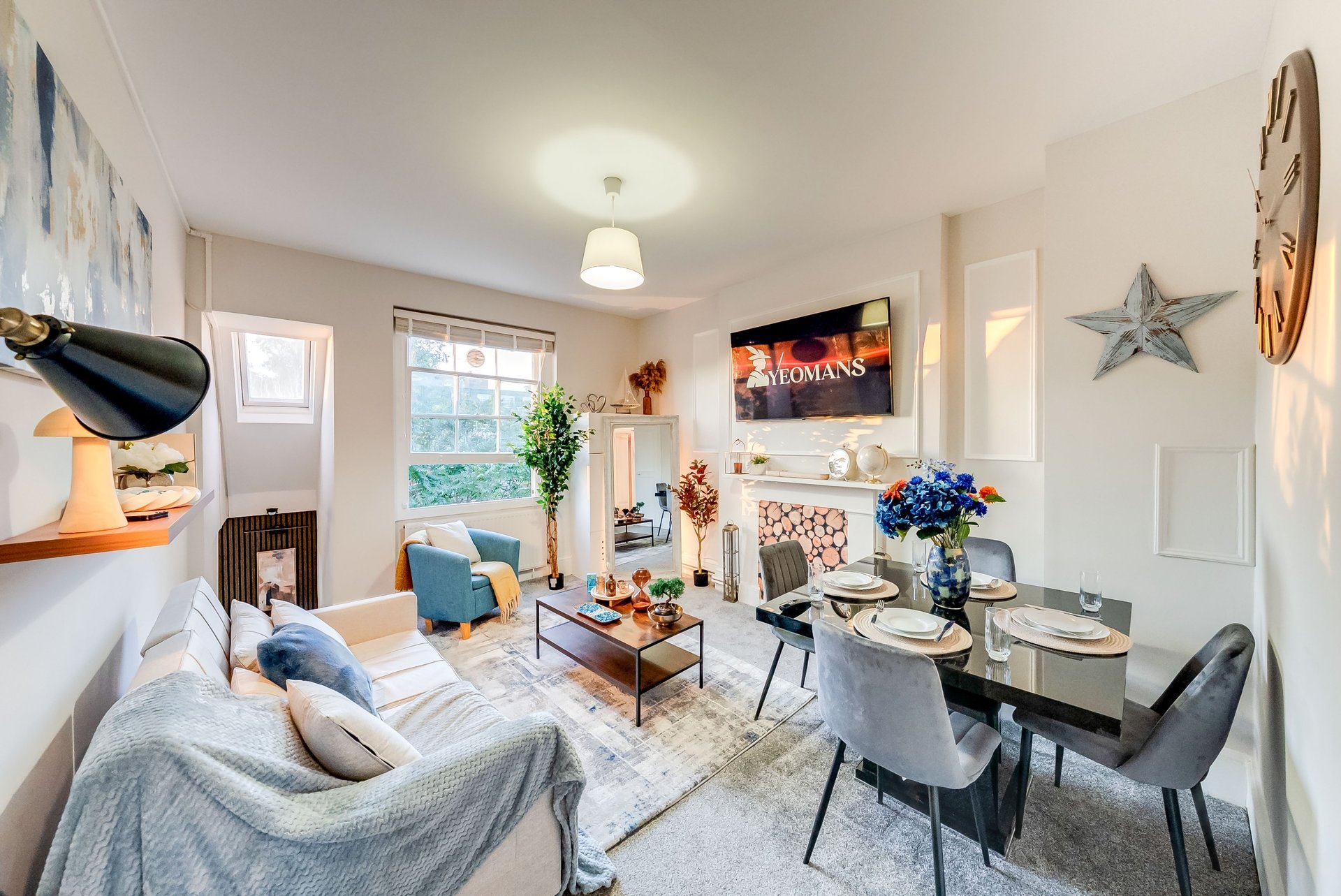 Open-plan living room with sofa, dining table, window seating area and modern decor