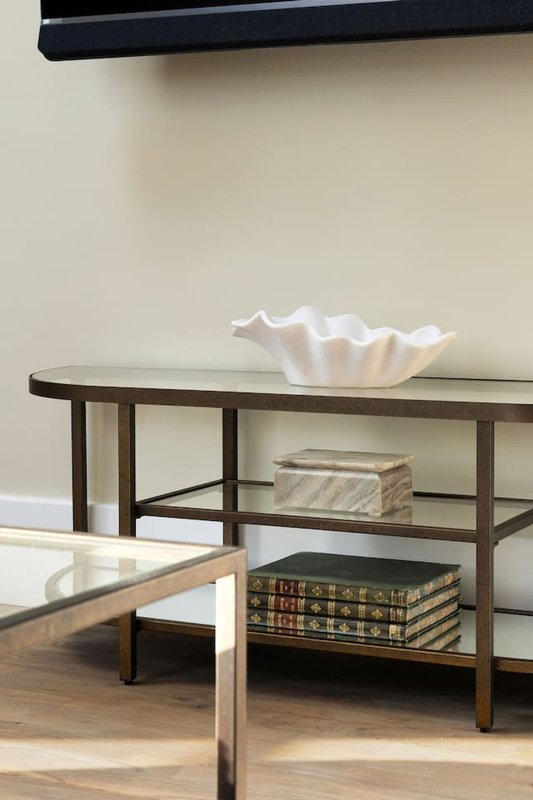 Living room with wooden console table, decorative white bowl, stacked books and minimal decor