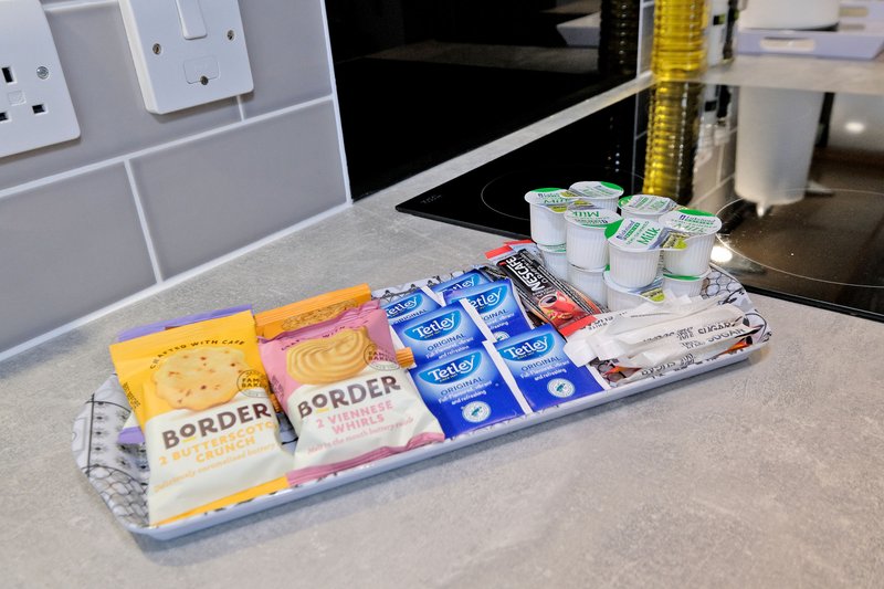 Kitchen counter with packaged food items, condiments, and household products arranged on tray