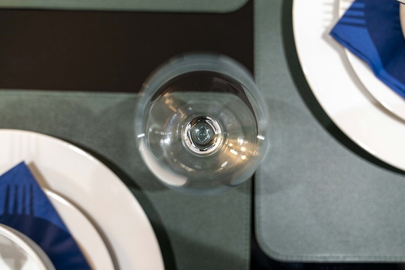 Close-up of clear glass wall-mounted light fixture with blue and white decor nearby