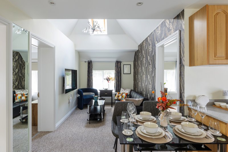 Open-plan dining and living area with laid table, seating area and windows