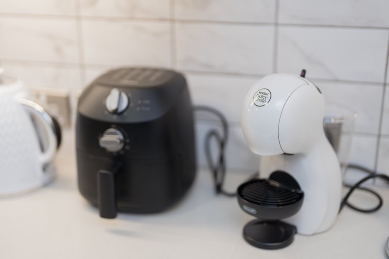 Kitchen counter with air fryer, coffee machine, and kettle appliances