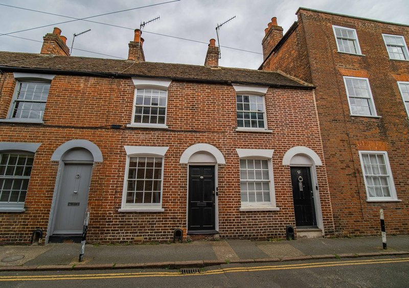 Traditional brick terraced houses with sash windows, front doors, chimneys and street view