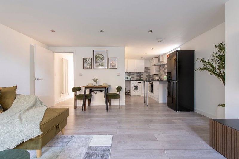 Open-plan studio apartment with bed, dining table, kitchen and living area
