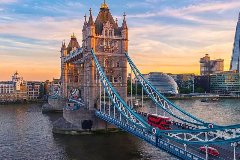 Tower Bridge in London spanning the River Thames at sunset with golden sky