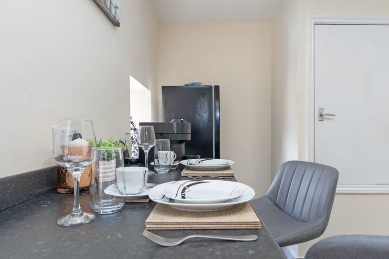 Modern kitchen counter with place settings, coffee maker, and decorative items