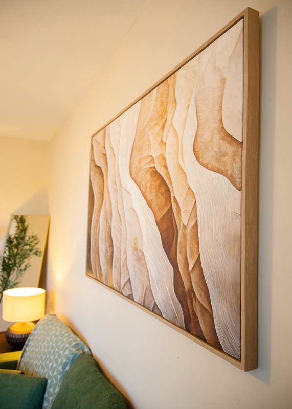 Bedroom corner with abstract wall art, bedside lamp, and potted plant