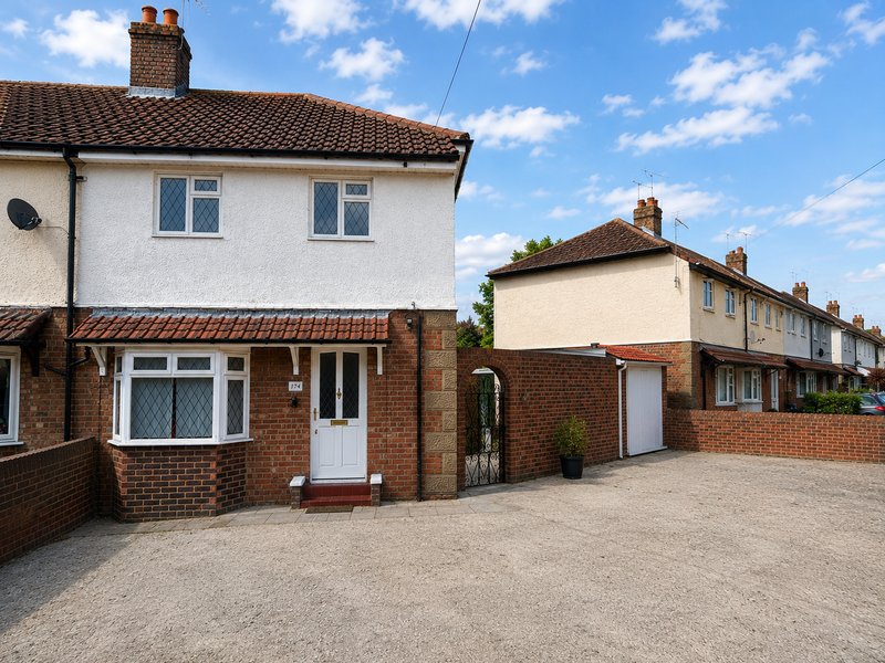 Semi-detached brick and rendered house with driveway, white door, and adjacent properties