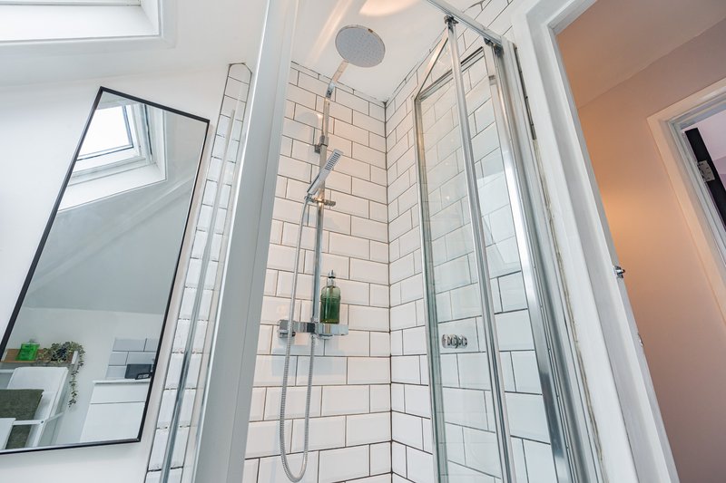 Modern bathroom with walk-in shower, white subway tiles, glass enclosure and chrome fixtures