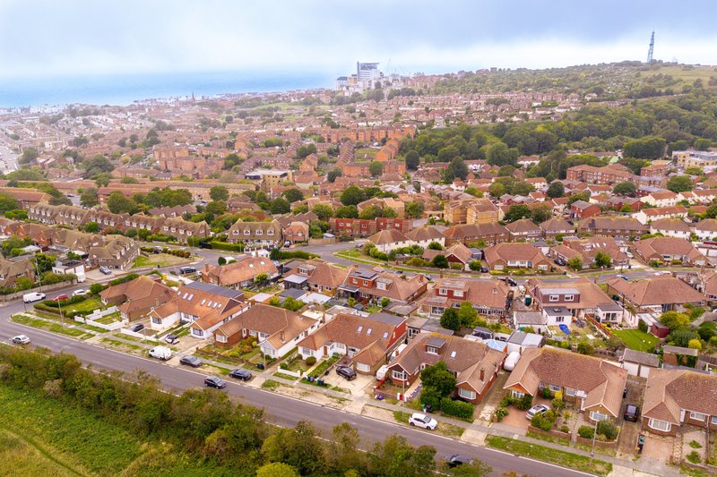 Aerial view of suburban residential neighborhood with brick houses, streets, and green spaces