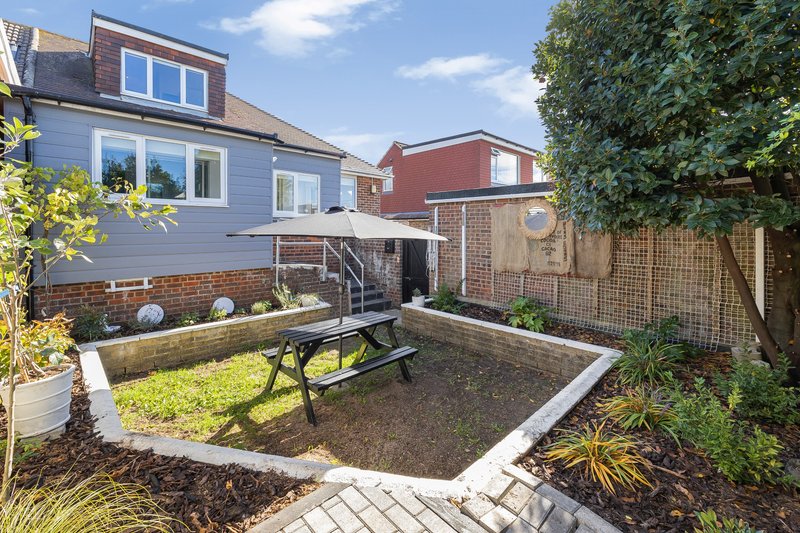 Rear garden with patio, picnic table, raised beds and ivy-covered fence