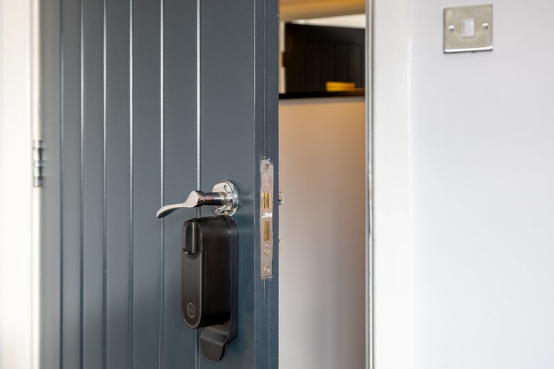 Partially open dark blue door with chrome handle and keypad lock system