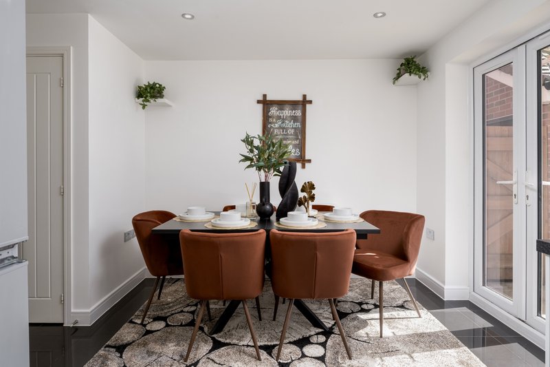 Modern dining room with round table, brown upholstered chairs, and wall decor