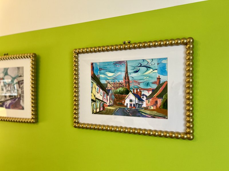 Bright lime green wall with two framed artworks in gold beaded frames