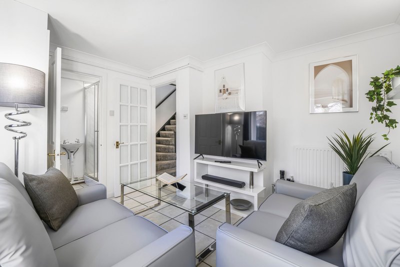 Modern studio bedroom with twin beds, TV, seating area and staircase access