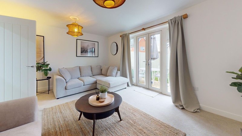 Bright living room with light blue sofa, round coffee table, glass doors and pendant lighting