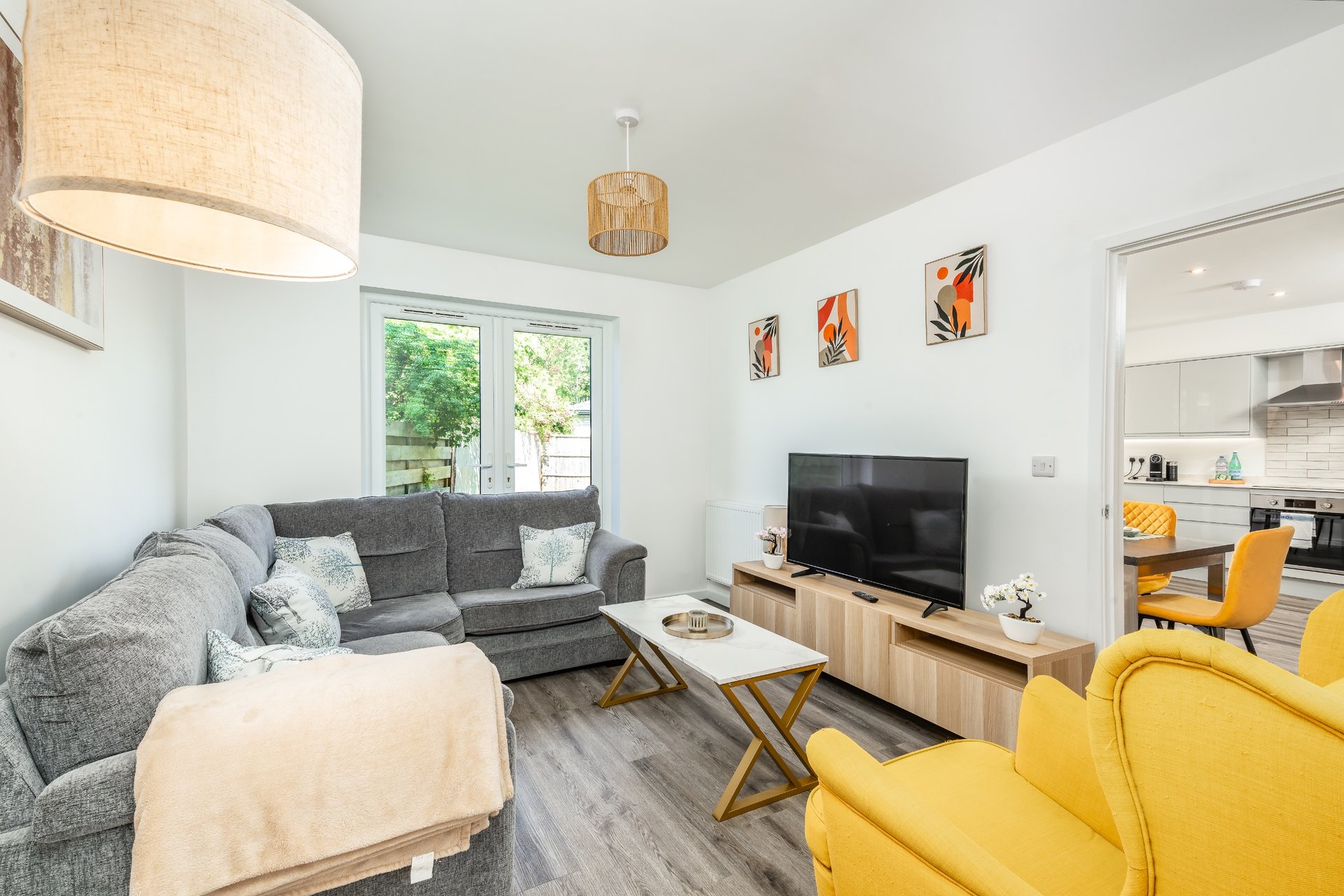 Modern living room with grey sofa, yellow armchair, TV stand and wooden coffee table