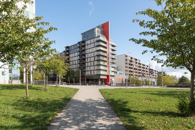 Modern residential apartment buildings with landscaped grounds and paved pathway