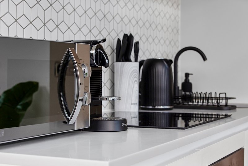 Modern kitchen counter with appliances, knife block, and decorative items