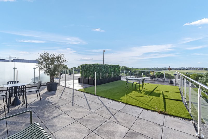Modern rooftop terrace with paving, seating, plants and countryside views