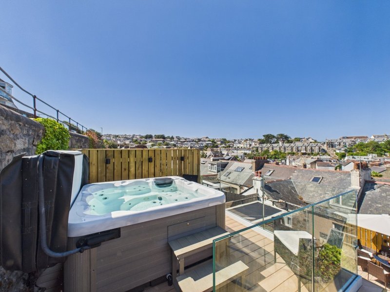 Rooftop terrace with hot tub, glass balustrade, and cityscape views