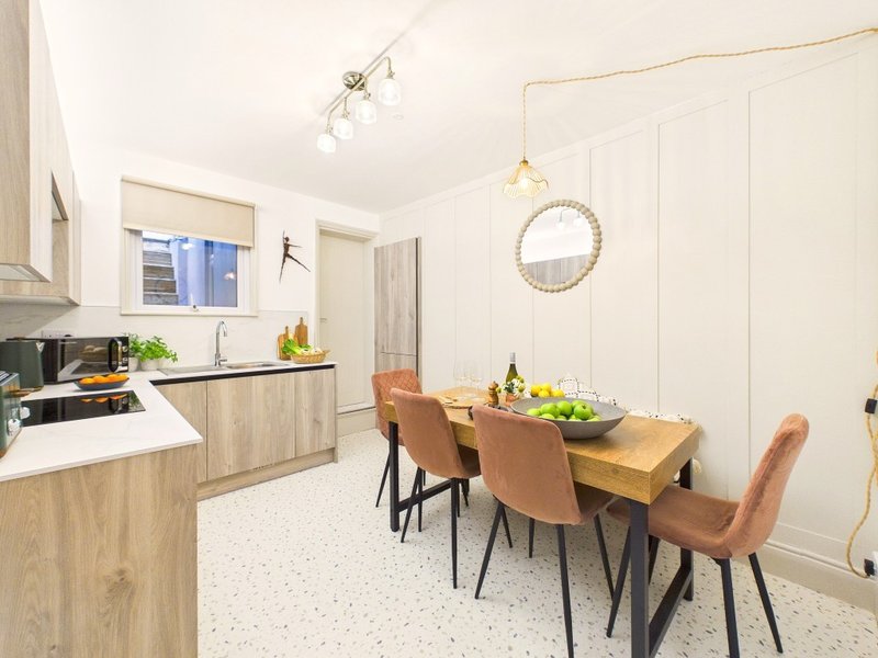Modern kitchen-diner with wooden cabinets, dining table, chairs and pendant lighting