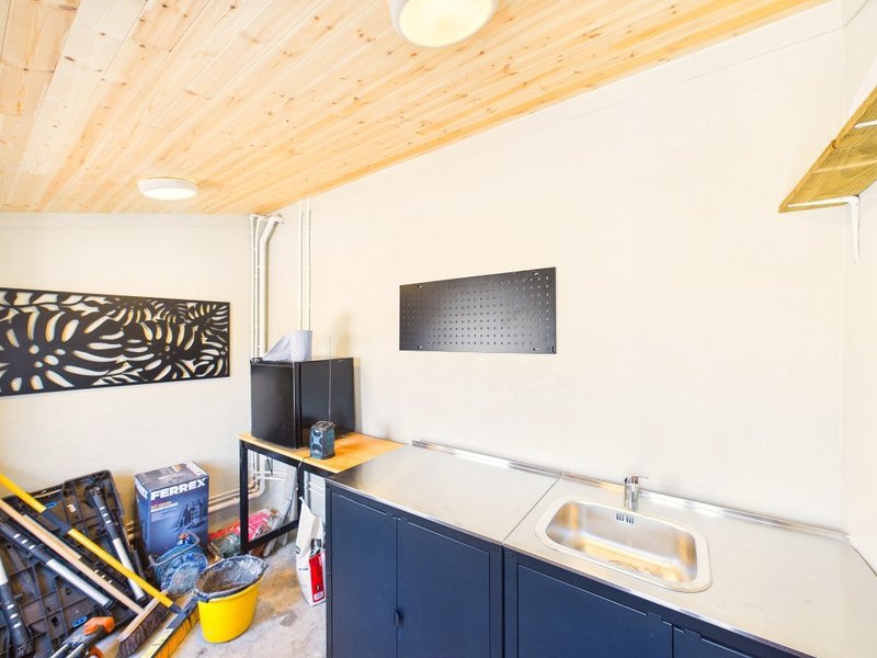 Kitchen area with wooden ceiling, navy cabinetry, sink, and workspace with decor