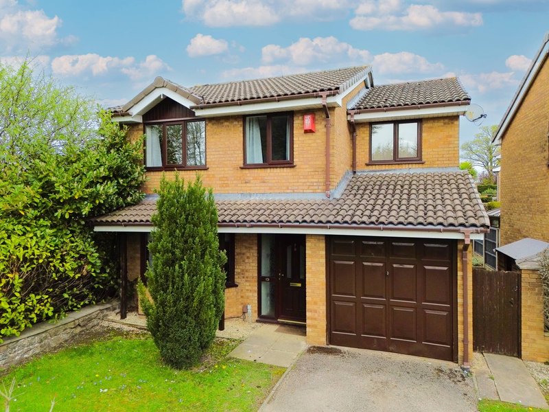 Two-story brick house with driveway, double garage, and front garden landscaping