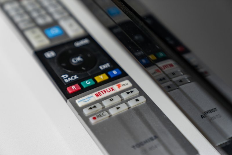 Close-up of remote control with colored buttons and Netflix branding