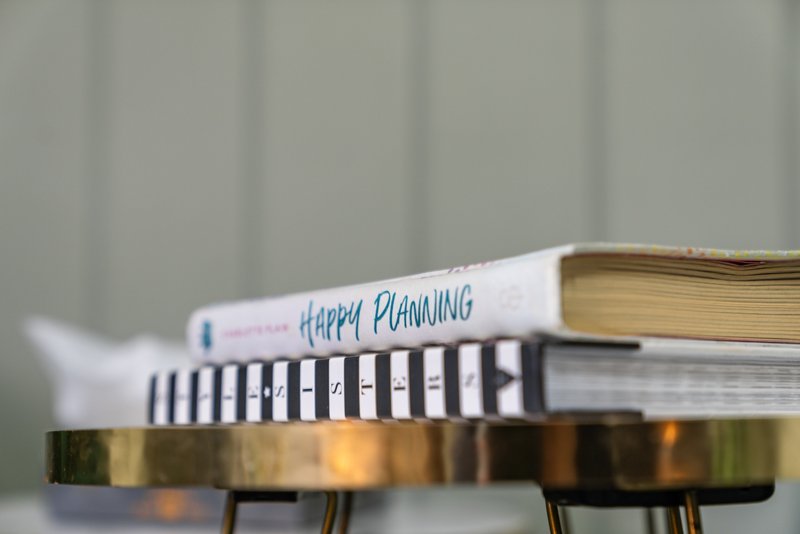 Stack of books on a table with blurred background, including planning book
