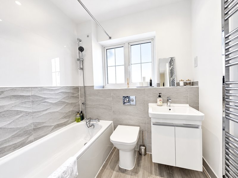 Main bathroom with bath, over bath shower and curtain, toilet and sink. Fresh towels are left for guests along with complimentary hand wash, shampoo, shower gel and toilet rolls.