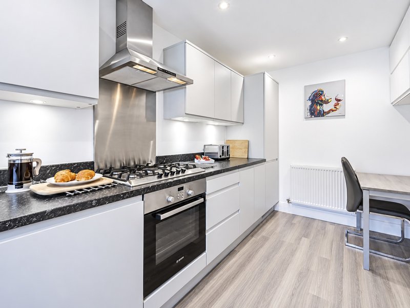 Modern kitchen with gas hob, electric oven, dishwasher, washing machine, microwave, coffee machine, kettle & toaster.