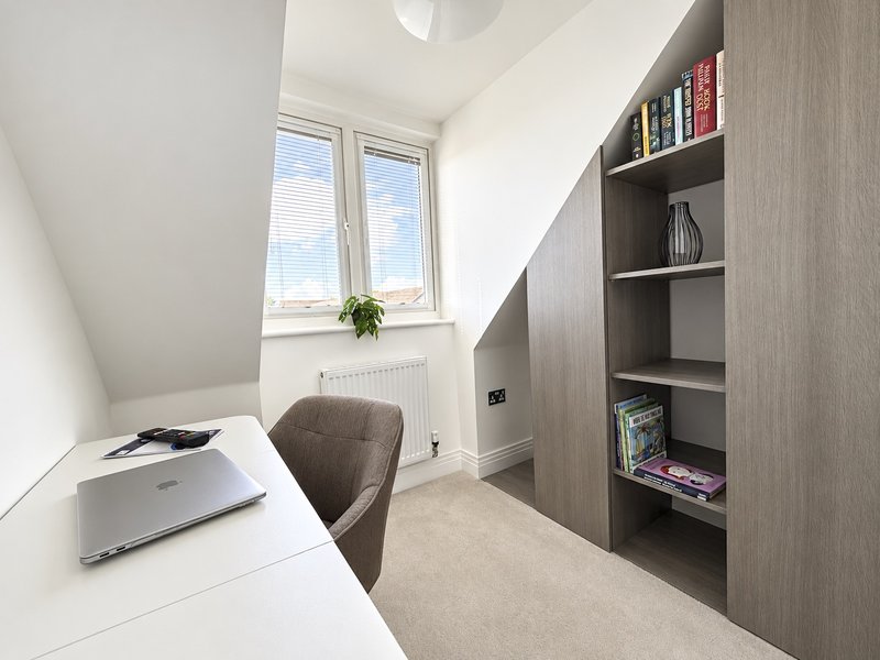 Bedroom 5 is a home office with desk and chair. Built-in shelving for additional storage.