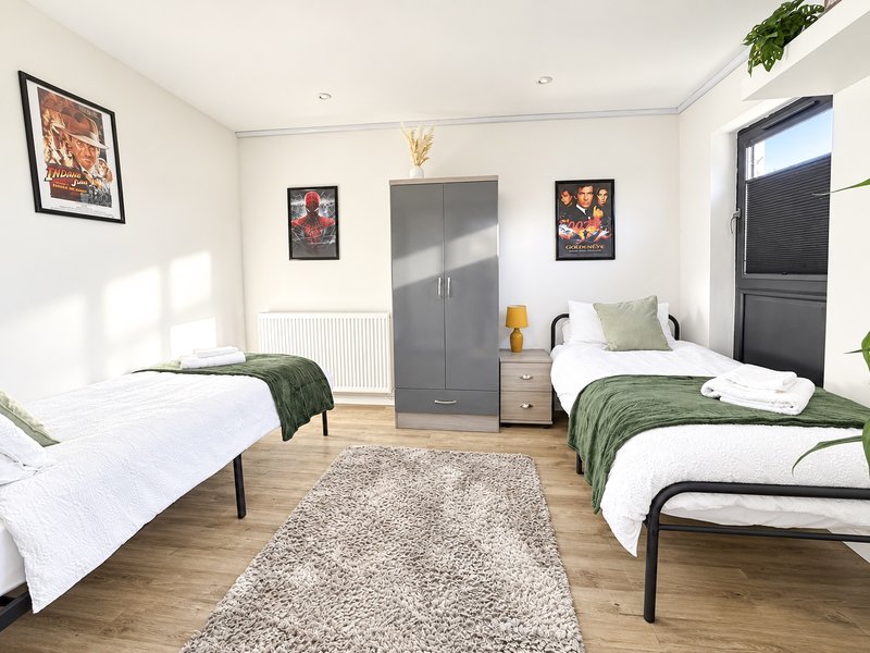 Ground floor bedroom with two single beds, wardrobe and bedside unit.