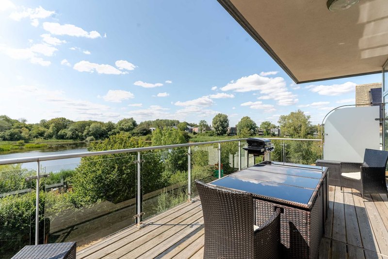 Rooftop terrace with ping pong table, river view and green landscaping beyond