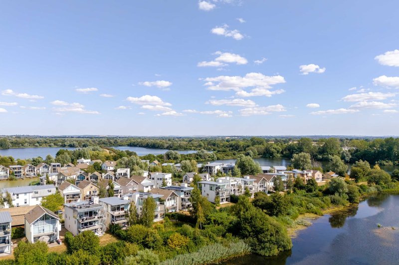 Aerial view of waterfront residential development with modern apartments and river landscape