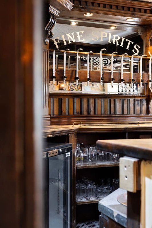 Built-in bar cabinet with fine spirits signage, glass bottles, and shelving