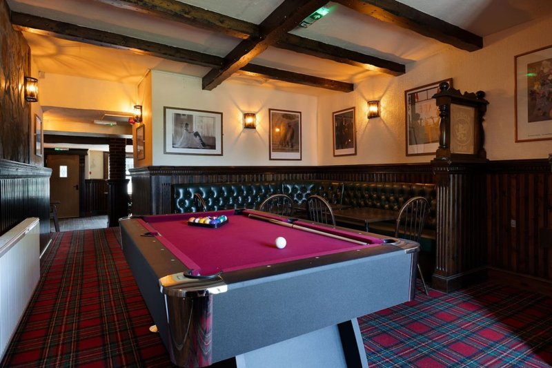 Game room with pool table, leather seating, exposed beams, and framed wall art