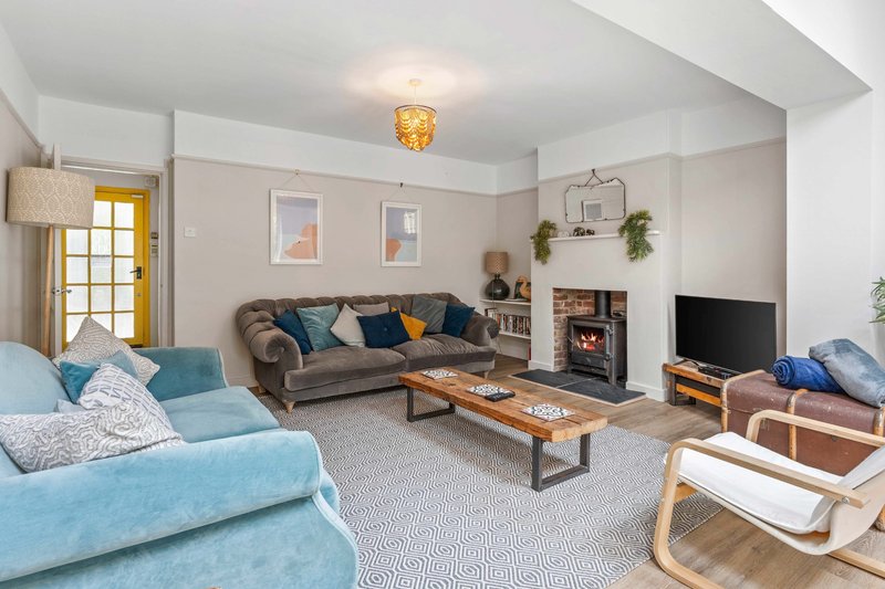 Spacious living room with light blue sofa, beige couch, wooden coffee table, fireplace and TV
