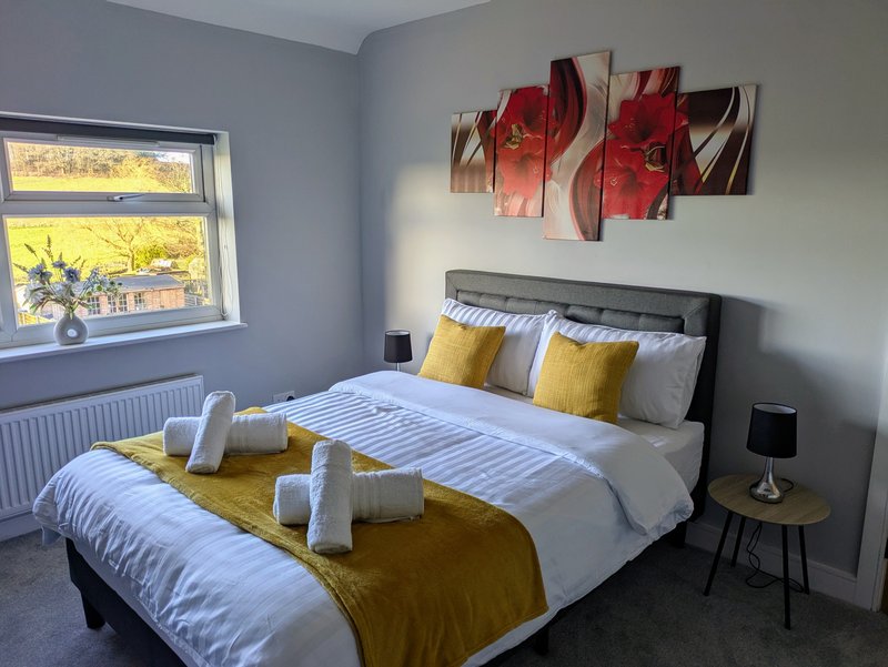 A bright and comfortable double bedroom featuring a spacious bed and fresh white linens and lovely views from the window. A peaceful space for working guests to unwind.